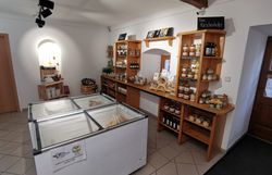 Innenraum des Hofladens mit Kühltruhen und Komoden mit Produkten.