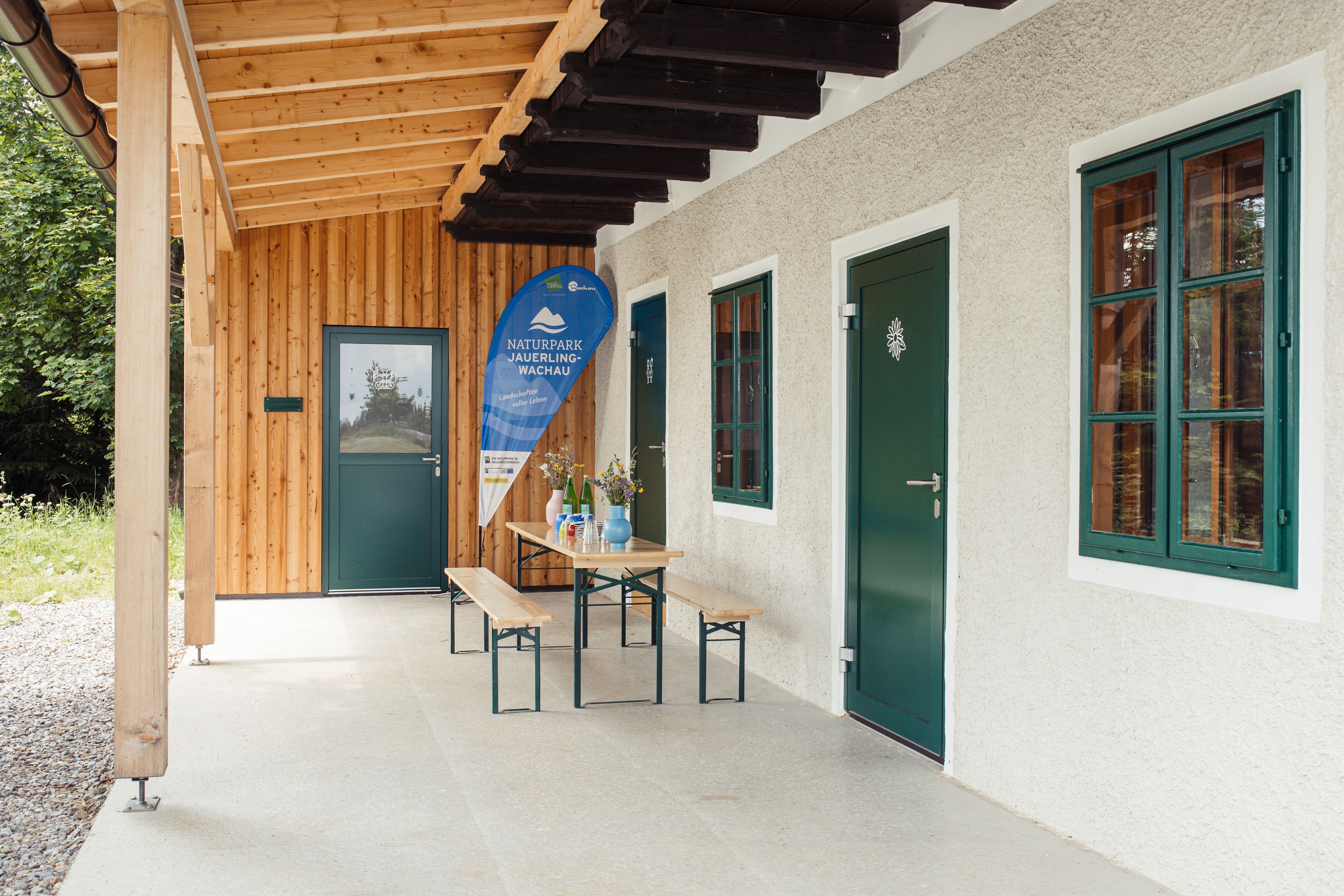 Eine Bank unter einem Vordach der Naturwerkstatt.