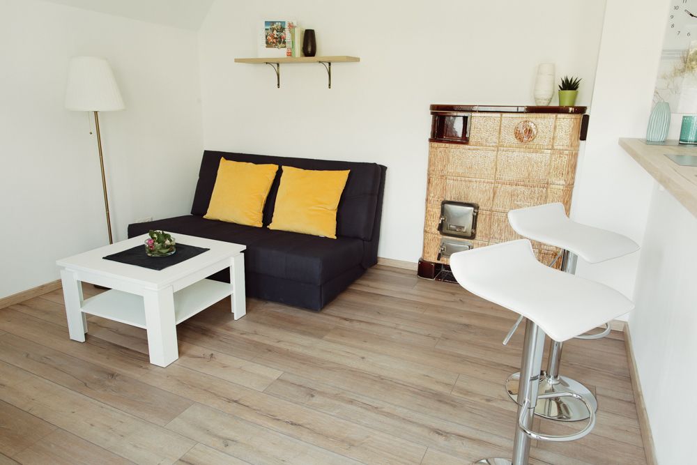 Modernes Wohnzimmer mit Sofa, Couchtisch, Barhockern und Kamin.