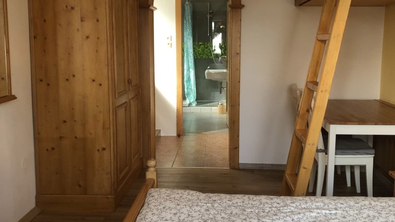 Interior view of a room with wooden furniture and a passageway to a bathroom.
