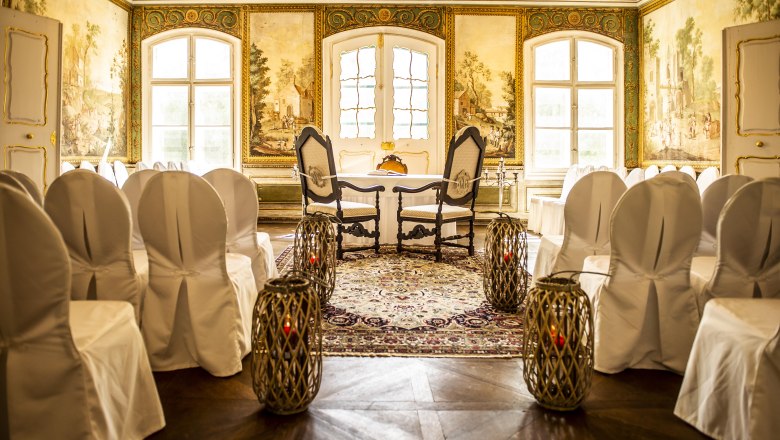 State Hall in Luberegg Castle with decorated chairs, carpet and murals.