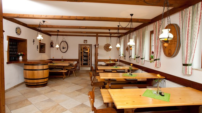 Interior view of a wine tavern with wooden tables, chairs and rustic decoration.