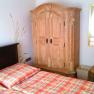Guest room with wooden furniture and checkered comforter cover.