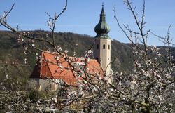 Eine kleine Kirche mit Rotem Dach und Turm mit Kupferspitze