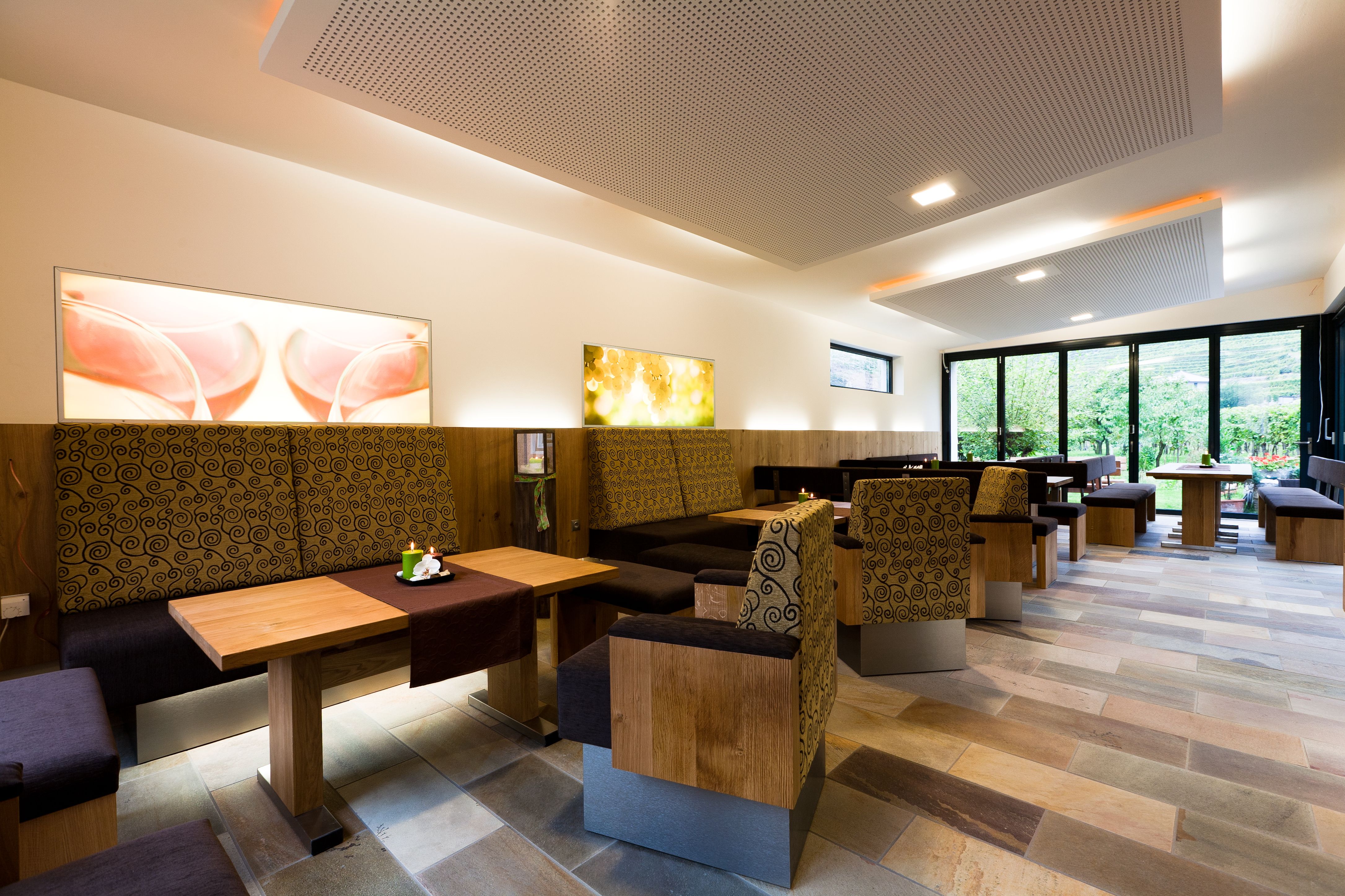 Innenansicht eines modernen Weinguts mit Holzmöbeln und großen Fenstern.