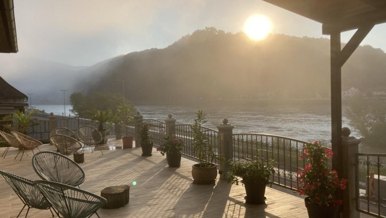 View from the terrace, © Georg Smolka Terrace with a view of the river and mountains at sunrise.