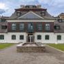 Exterior view of Schloss Luberegg with fountain in the foreground.