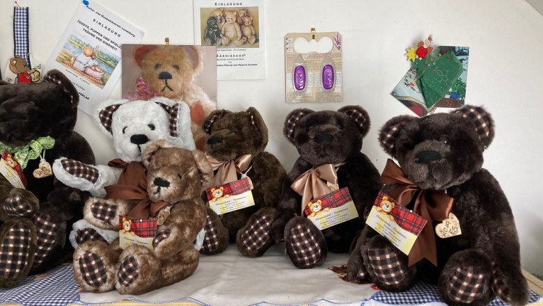 A collection of plush bears with checkered bows on a table.