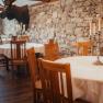 Rustic restaurant with stone wall, wooden furniture and candlesticks.
