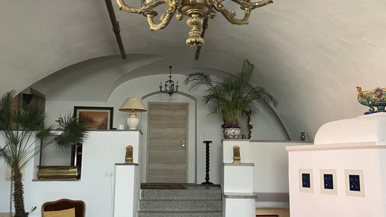 Elegant room with chandelier, fireplace and staircase.