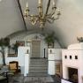 Elegant room with chandelier, fireplace and staircase.