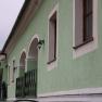 Green building with white window frames and lanterns.