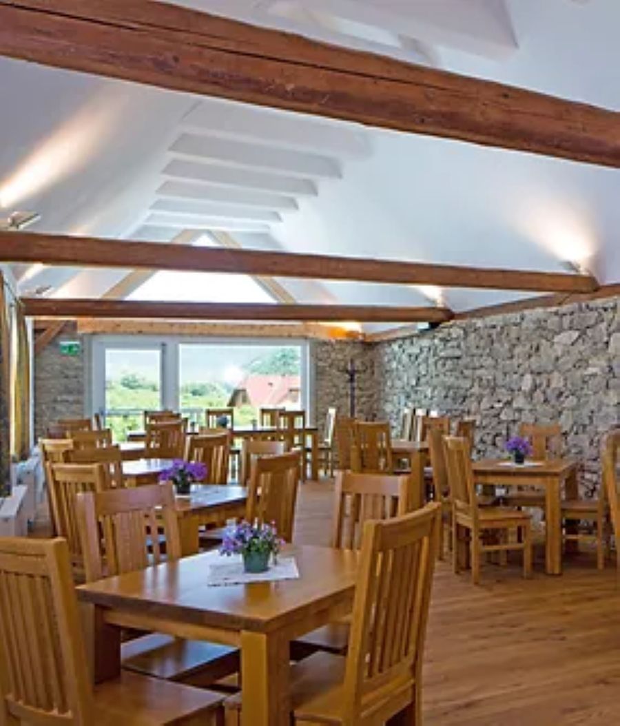 Speisesaal mit Holztischen und Holzstühlen