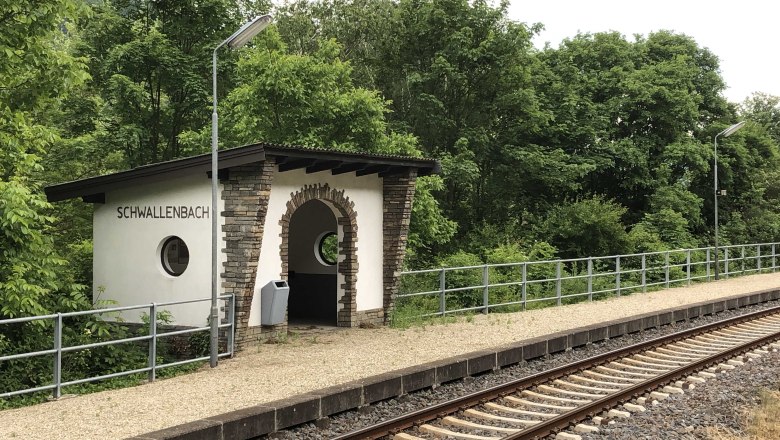 Small Schwallenbach station with tracks and surrounding nature.