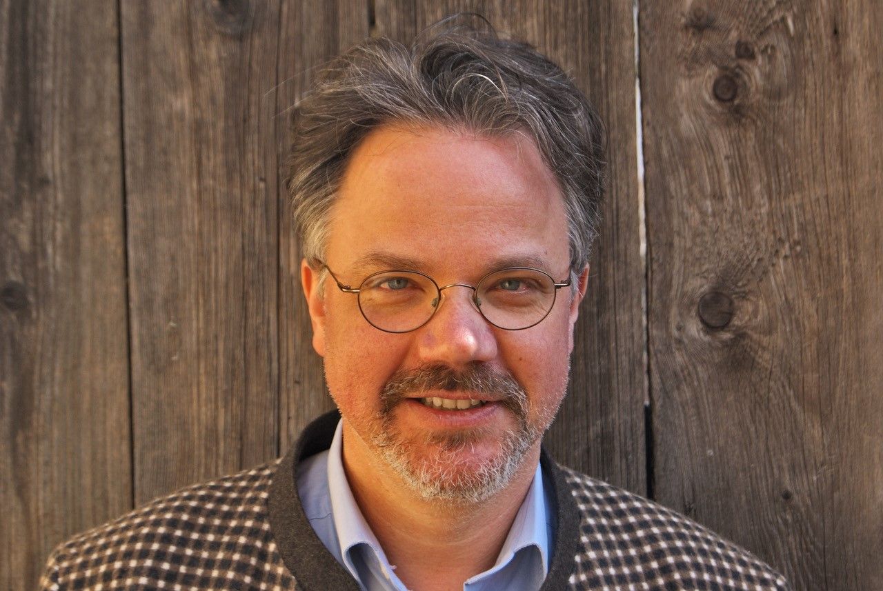 Markus Zuba vor einer Holzwand 