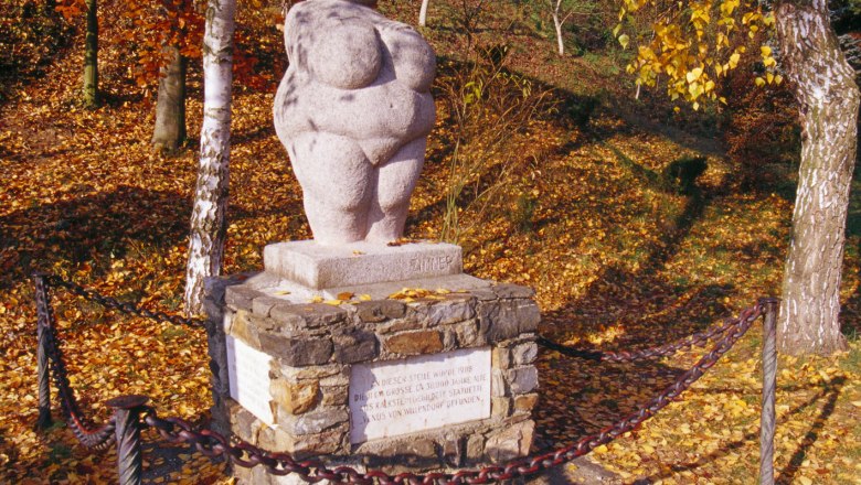 Venus on the pedestal with autumn leaves around it