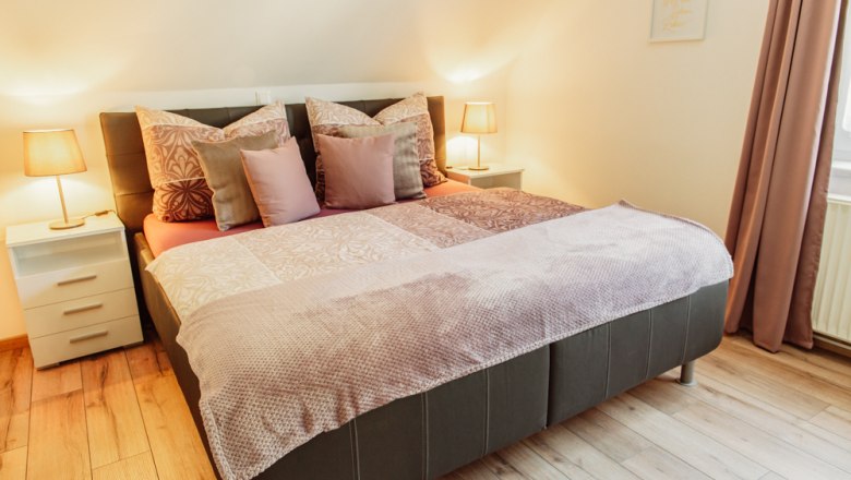 Cozy bedroom with double bed, bedside tables and lamps.