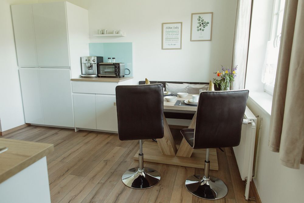 Moderne Küche mit Esstisch, Stühlen und Geräten.