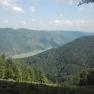 View of wooded hills and a river under a blue sky from the Jauerling.