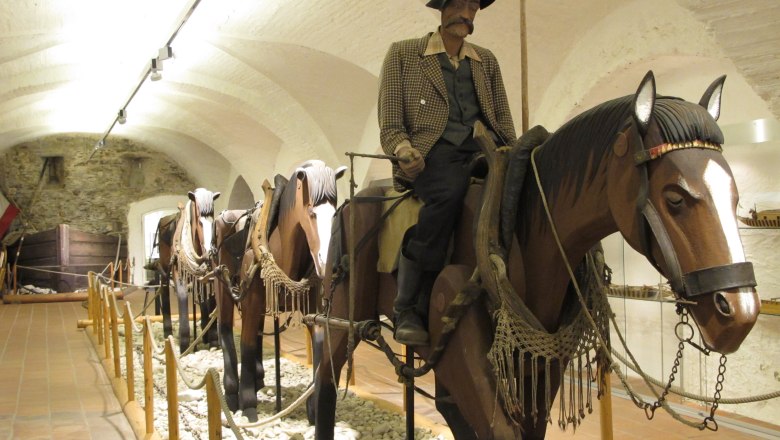 Ausstellungsobjekt im Schifffahrtsmuseum mit Figuren auf Holzpferden.