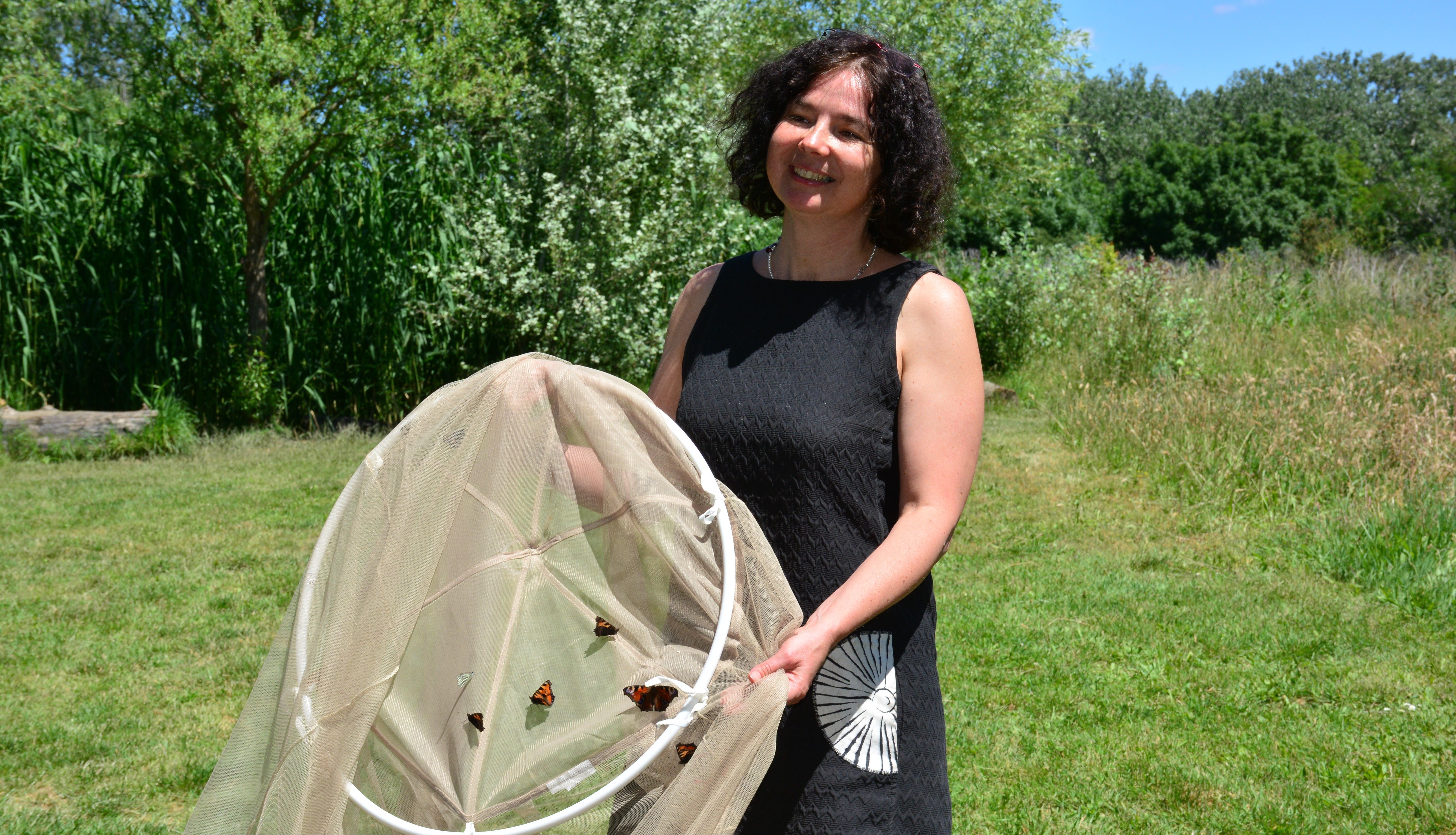 Maria Jaros hält ein Insektennetz in der Hand.