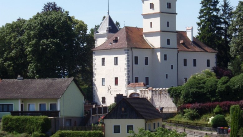 Rothenhof Castle in Emmersdorf surrounded by trees and buildings.
