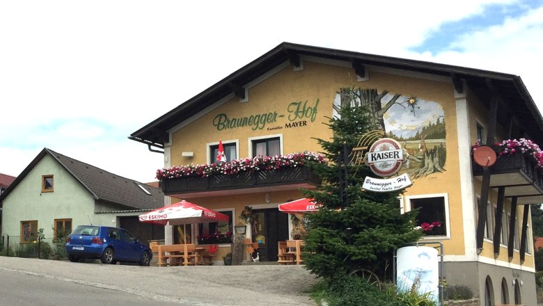 Gasthof Braunegger-Hof with balcony flowers and parasols.