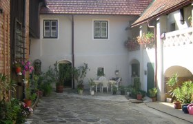 Innenhof eines traditionellen Hauses mit Pflanzen und Sitzbereich.