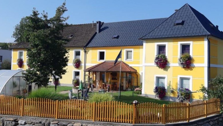 Aussenansicht, © Familie Pemmer Gelbes Haus mit Garten und Holzzaun