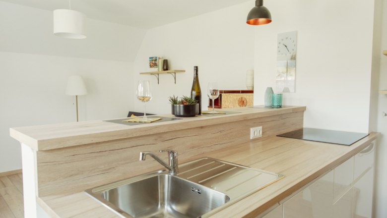 Modern kitchen with wooden worktop, sink and decoration.