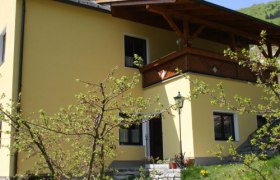 Gelbes Haus mit bl&uuml;hendem Baum