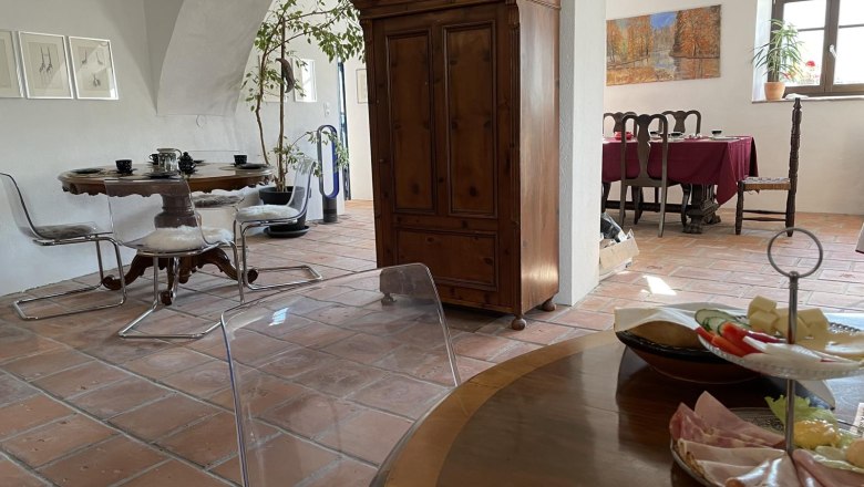 Interior view of a cozy room with wooden furniture, dining table and decorations.
