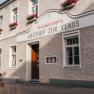Gasthof zur Venus mit blumengeschm&uuml;ckter Fassade und Holzt&uuml;r.