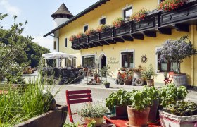 Gemütliches Gasthaus mit Blumenschmuck und Terrasse, ländliche Atmosphäre.